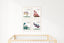 Four pastel dragon prints as a grid above a light wood crib