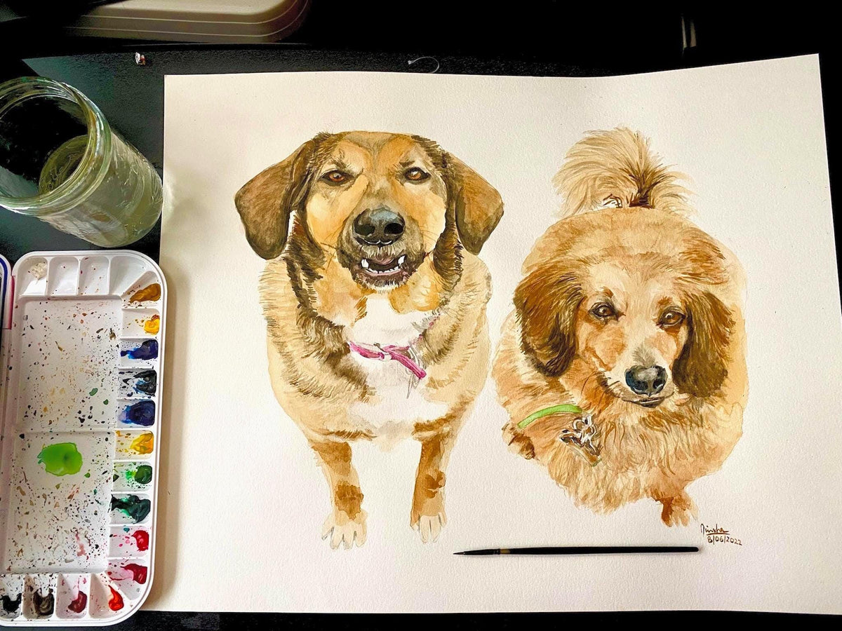 Watercolour portrait of two dogs together from a photo, a tan mix and a fluffy golden, next to paints