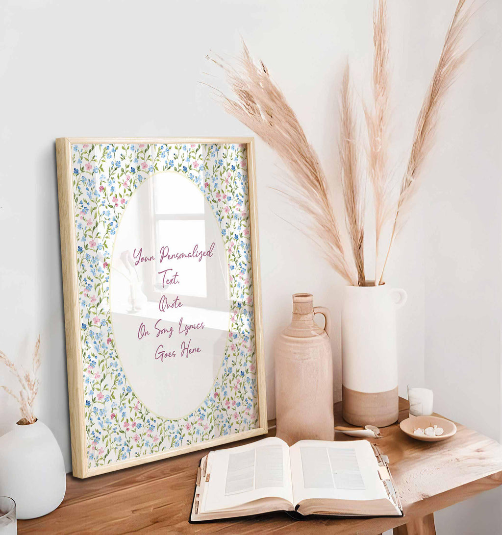 Floral wedding vows print in an oak frame on a wooden desk styled with pampas grass and an open book