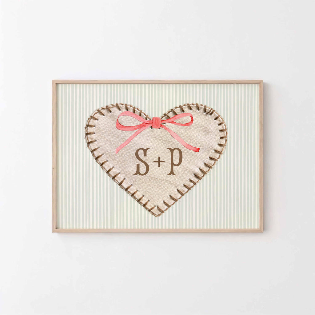 Initials heart print: stitched fabric heart with S + P and a pink bow on a sage stripe background