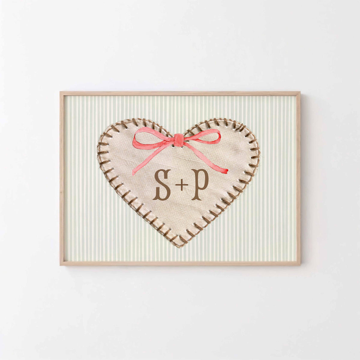 Initials heart print: stitched fabric heart with S + P and a pink bow on a sage stripe background